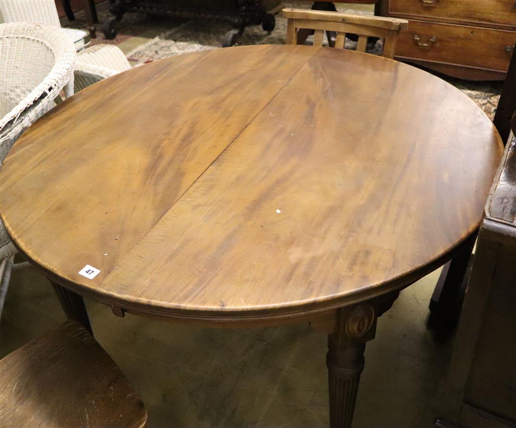 An early 20th century mahogany circular extending dining table, 180cm extended (two spare leaves)